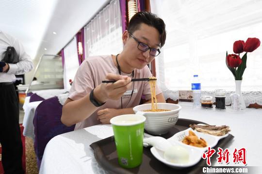 圖為旅客在列車上享用正宗牛肉面?！钇G敏 攝